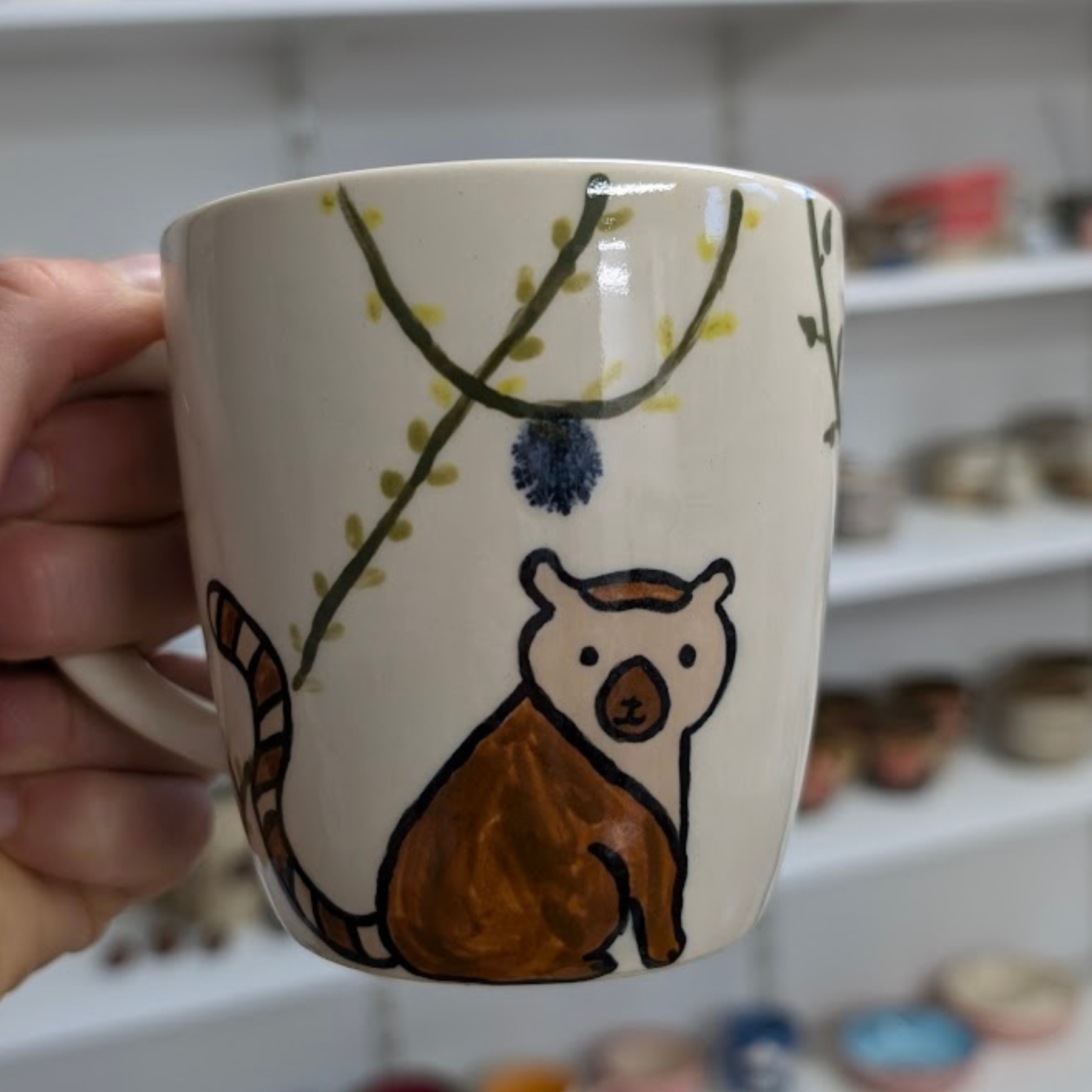 malowanie-ceramiki-gdansk-kubek038l-las-lemur-brazowy Ceramiczny kubek o pojemności 0,38l z warsztatów malowania ceramiki w Gdańsku. Na kremowym tle namalowany brązowy lemur z charakterystycznym pasiastym ogonem oraz zielone gałązki z żółtymi listkami. Oryginalny ręcznie zdobiony kubek wykonany podczas kreatywnych warsztatów malowania ceramiki w Gdańsku.