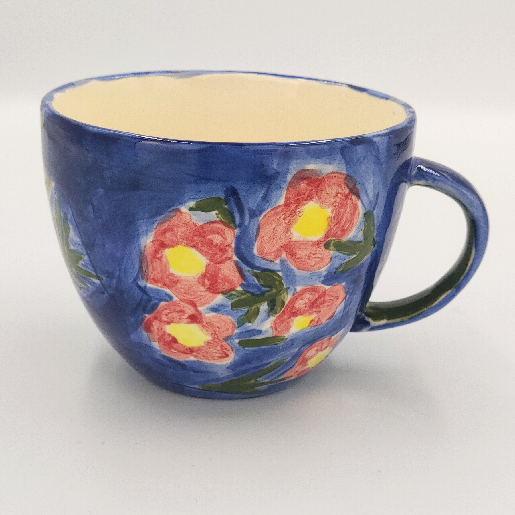 malowanie ceramiki gdansk kubek065l kwiaty niebieskie Niebieski kubek 0,65l z dekoracyjnymi różowymi kwiatami stworzony na warsztatach malowania ceramiki w Gdańsku