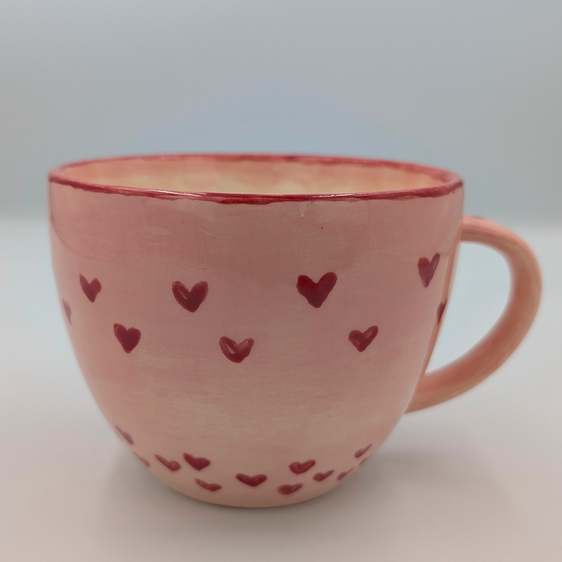 malowanie ceramiki gdansk kubek065l serduszka Różowy kubek 0,65l z motywem czerwonych serduszek stworzony na warsztatach malowania ceramiki w Gdańsku