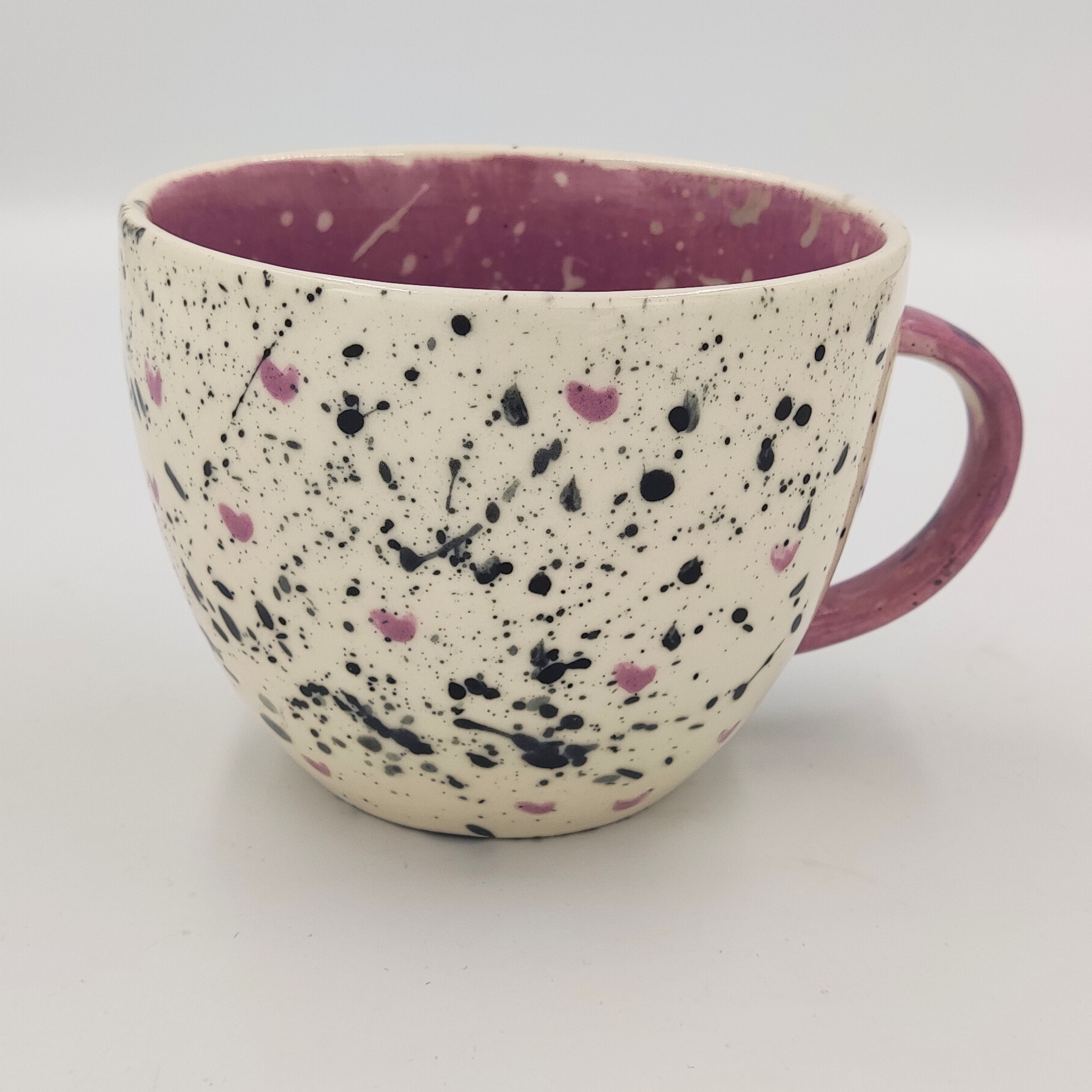 malowanie ceramiki gdansk kubek065l splash czarno rozowy Kremowy kubek 0,65l z czarno-różowymi plamkami namalowany przez uczestnika warsztatów ceramicznych w Gdańsku