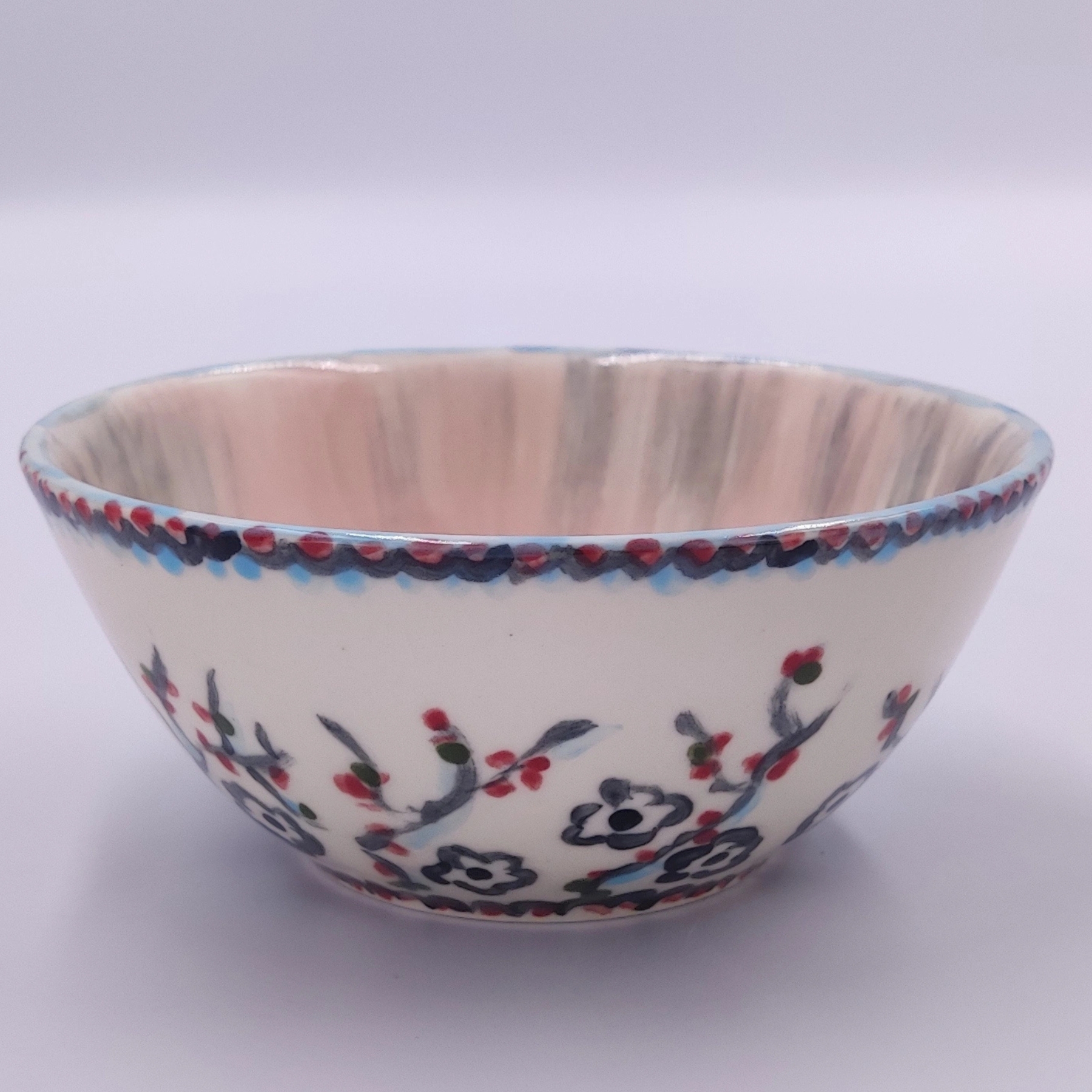 malowanie-ceramiki-gdansk-salaterka12cm-kwiaty-jagody-kremowa Ręcznie malowana salaterka ceramiczna o średnicy 12 cm z warsztatów malowania ceramiki w Gdańsku. Kremowe naczynie zdobione delikatnymi czarnymi kwiatami i czerwonymi jagodami, z ozdobnym niebiesko-czerwonym wzorem na krawędzi. Unikatowa ceramika użytkowa wykonana podczas kreatywnych warsztatów w Gdańsku.
