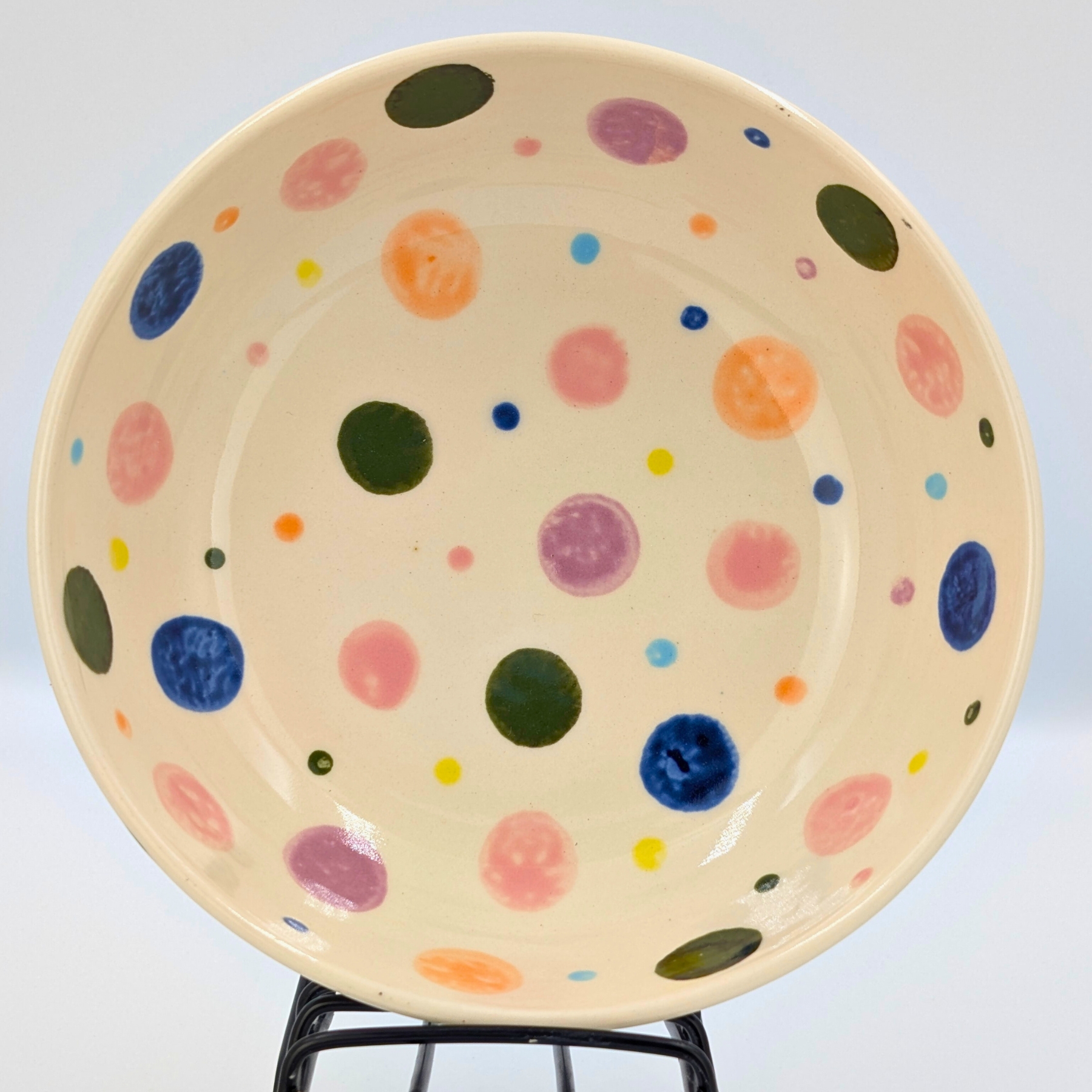 malowanie-ceramiki-gdansk-salaterka18cm-kropki-kolorowe-kremowa remowa salaterka o średnicy 18cm z warsztatów malowania ceramiki w Gdańsku, ozdobiona kolorowymi kropkami w odcieniach różu, niebieskiego, zieleni, pomarańczu i fioletu. Ręcznie malowane naczynie wykonane podczas twórczych warsztatów, idealne do serwowania przekąsek lub sałatek.