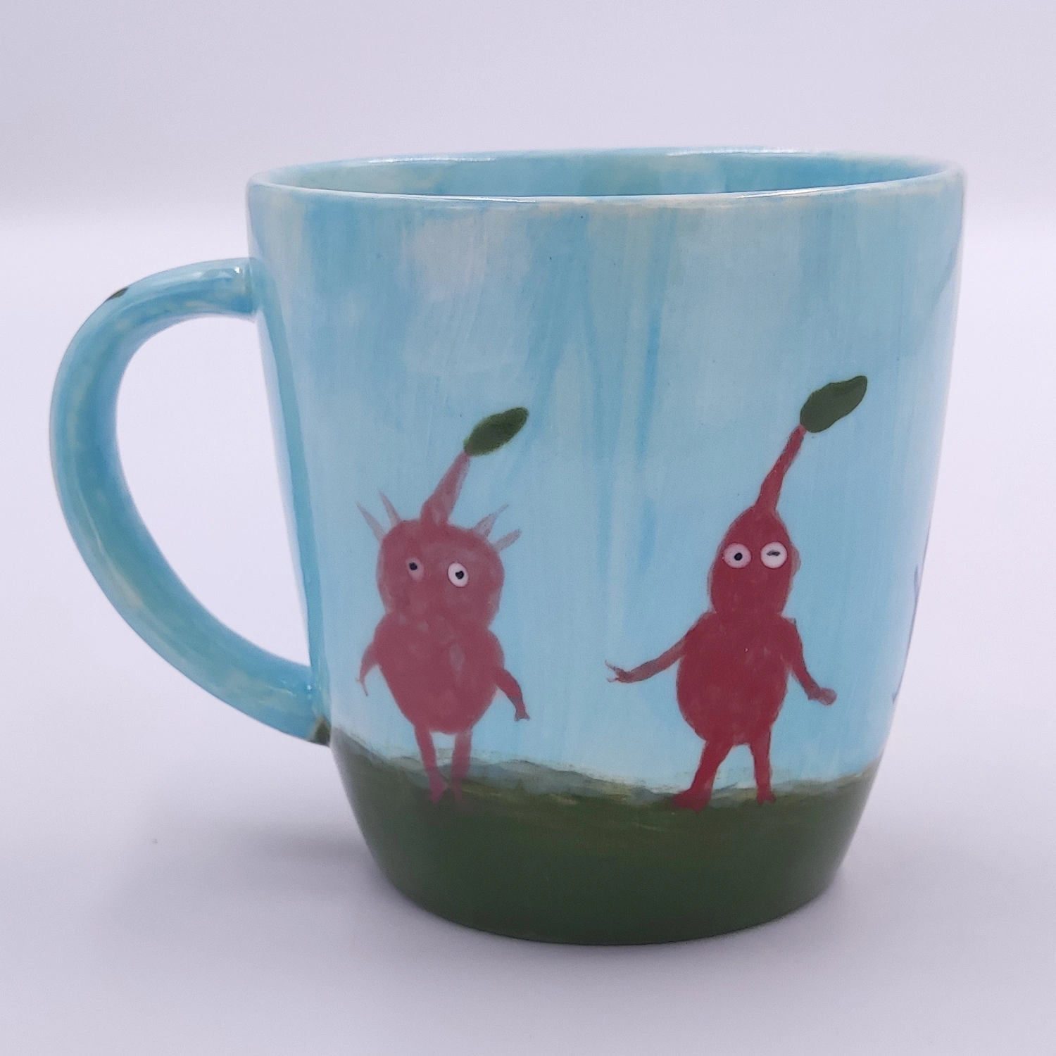 malowanie_ceramiki_gdansk_kubek038l_czerwone_stworki Błękitny kubek 0,38l z zabawnymi czerwonymi postaciami - kreatywna praca z warsztatów malowania ceramiki Gdańsk